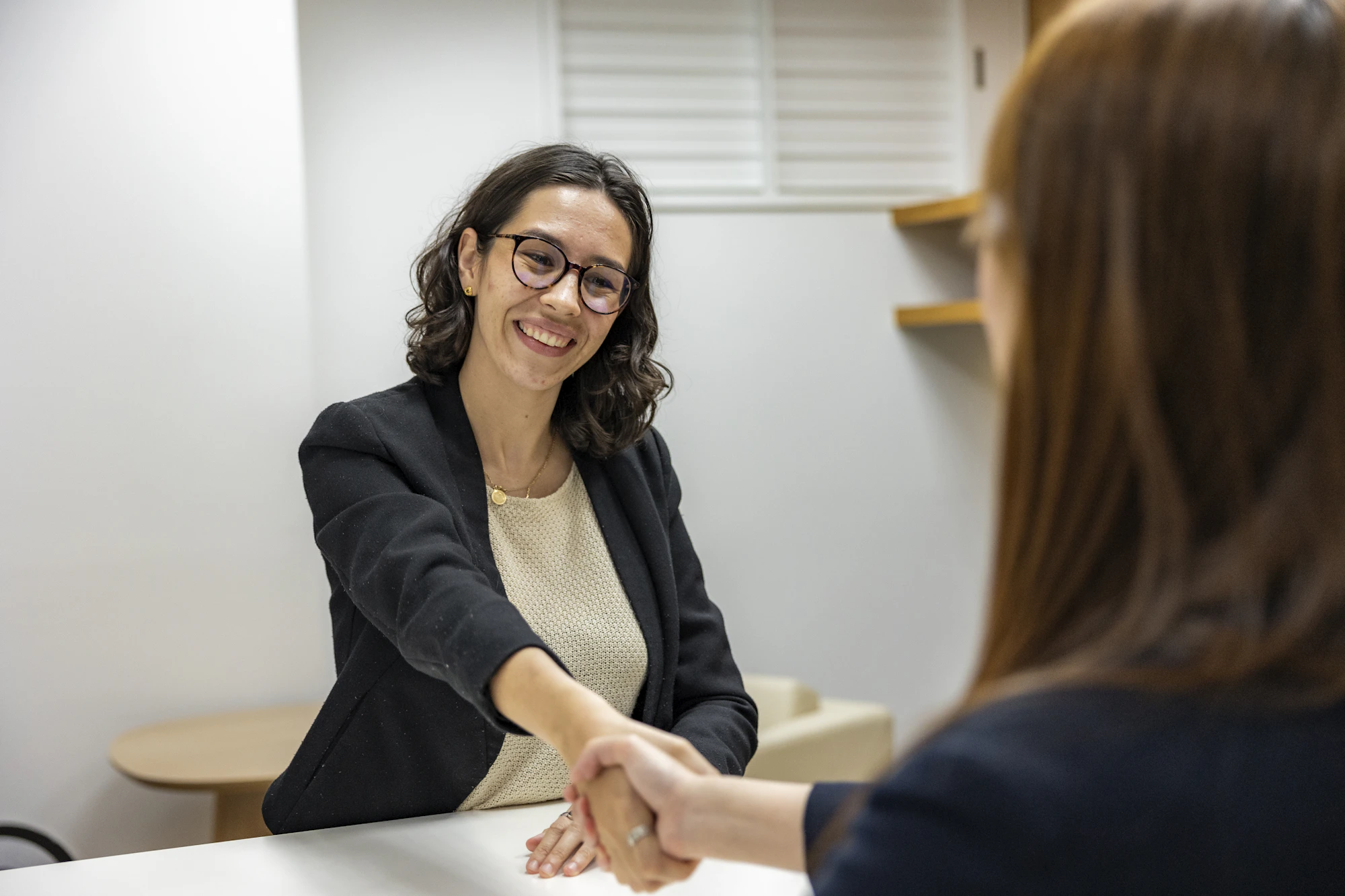 A smiling recruiter shaking hands with a candidate